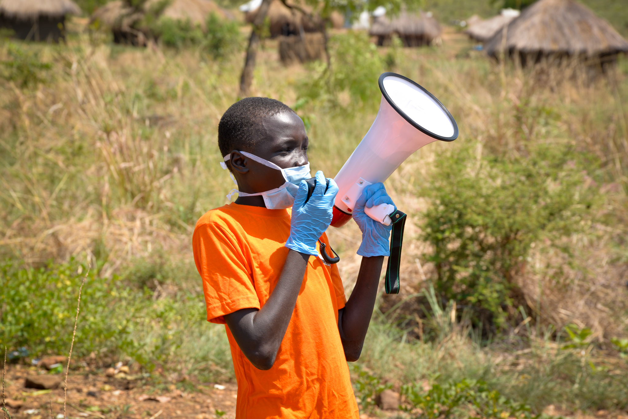 William hilft mit Flüchtlinge in Uganda über das richtige Verhalten in Corona-Zeiten zu informieren.