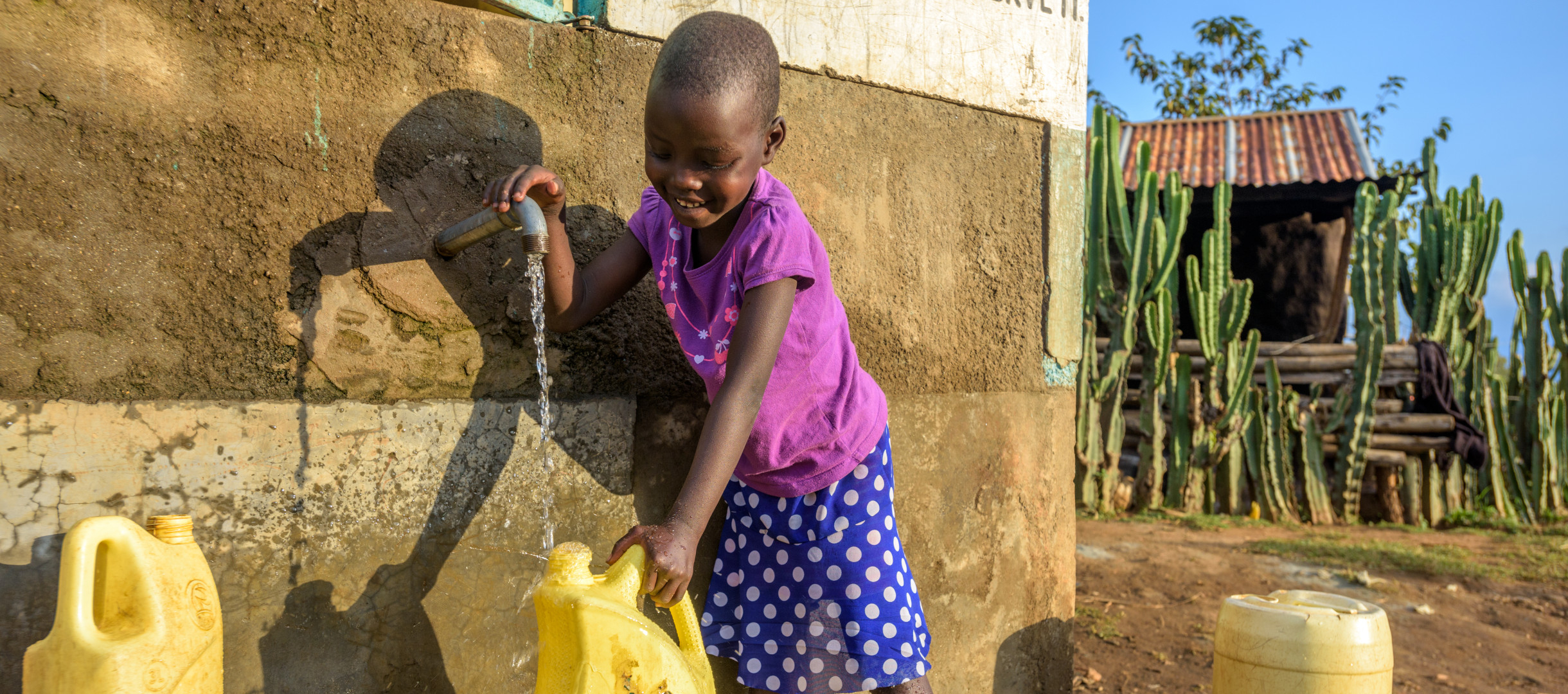 Patenkind Kamama aus Kenia zapft Trinkwasser