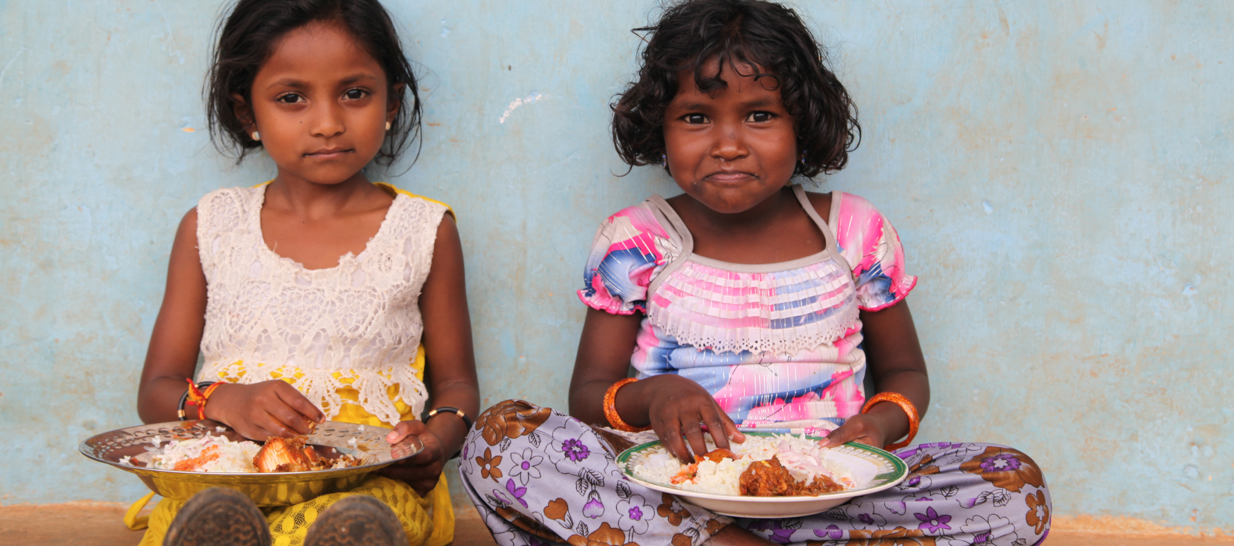 Zwei Mädchen in Indien bei einer Mahlzeit mit Reis