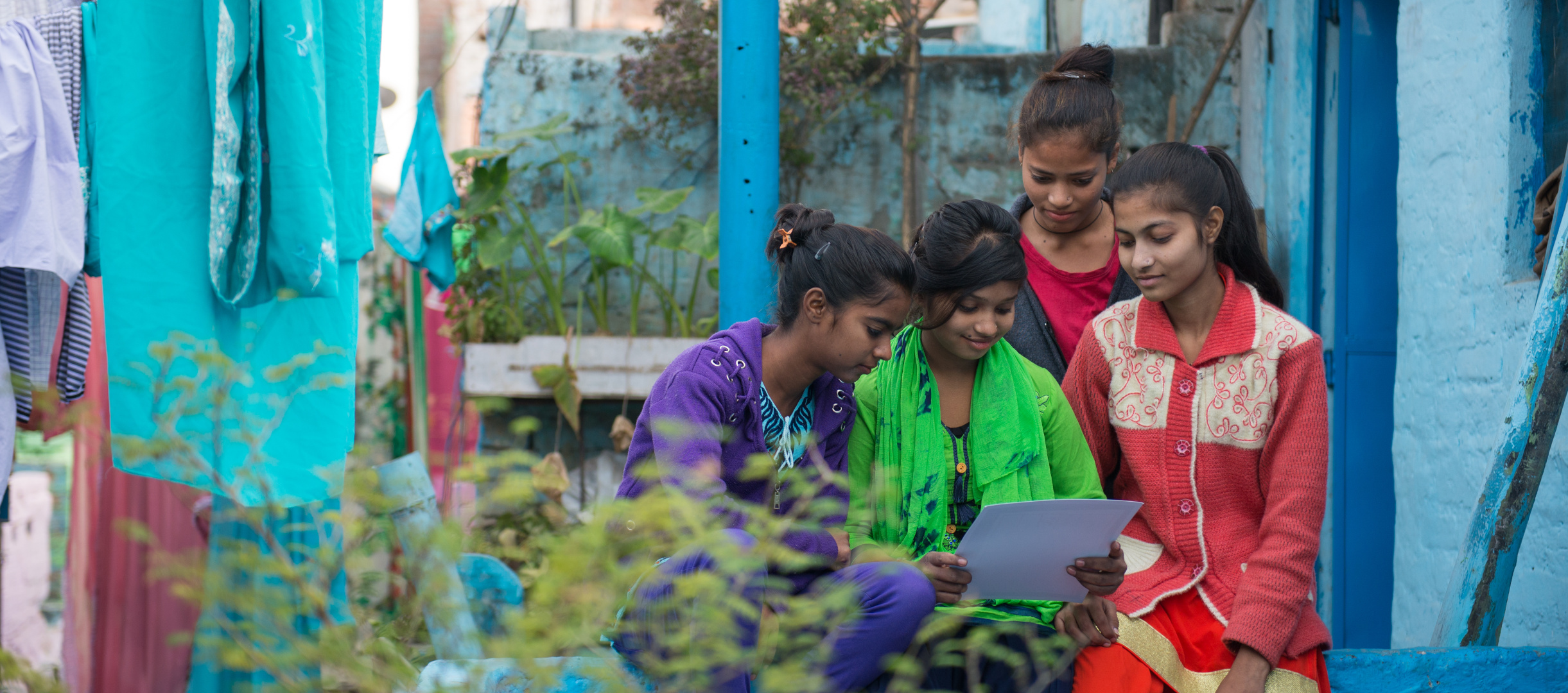 Patenkind Tamanna aus Indien liest ihre Patenpost mit ihren Freundinnen