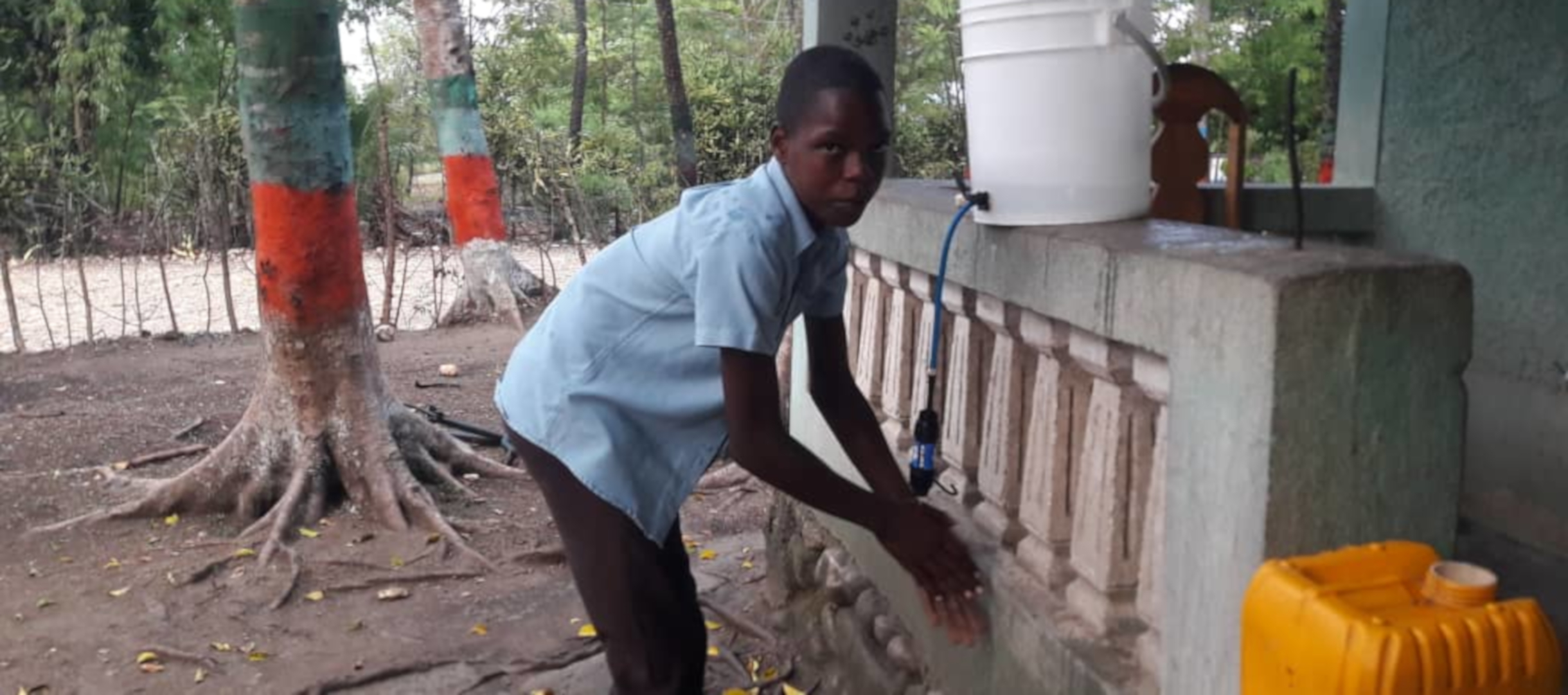 Patenkind aus Haiti wäscht sich die Hände.