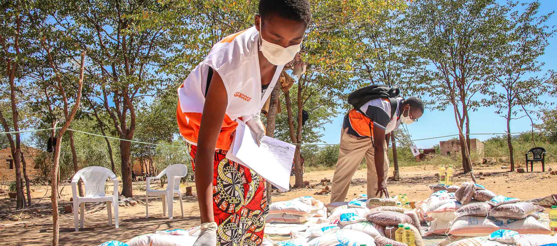 Mitarbeiter mit Maskenschutz bei einer Lebensmittelausgabe in Sambia.
