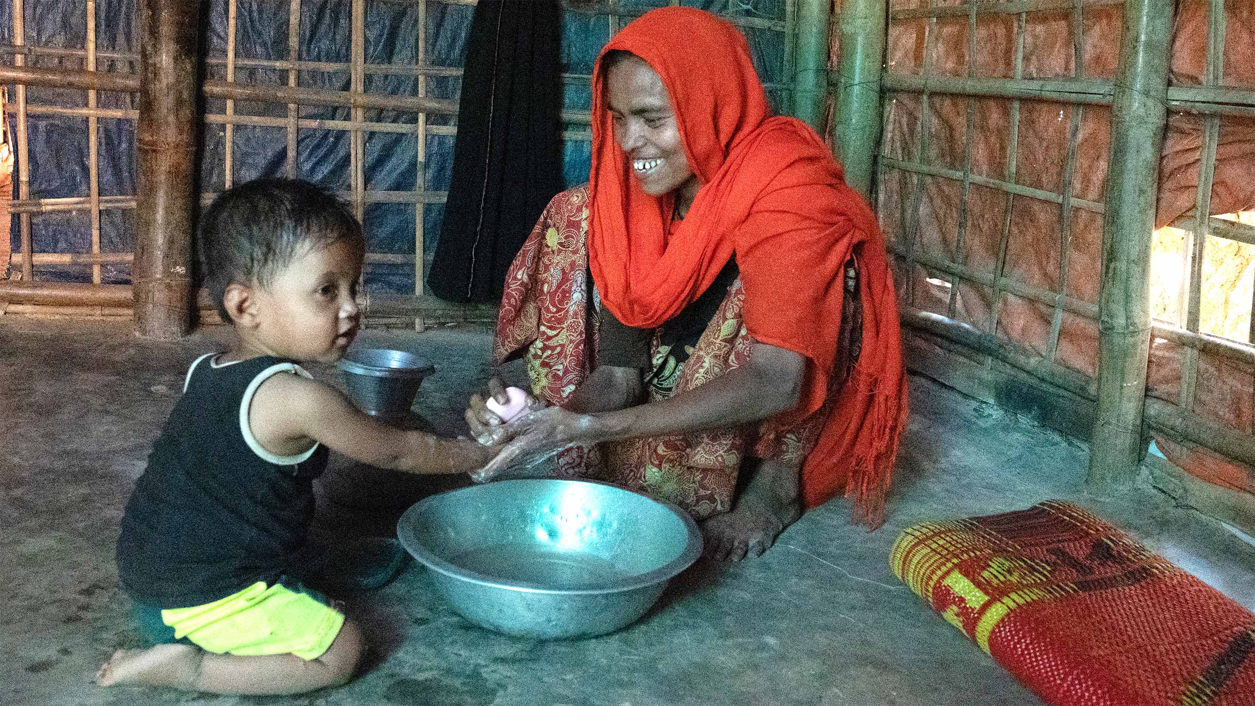 Mutter im Flüchtlingscamp in Bangladesch wäscht ihrer Tochter die Hände