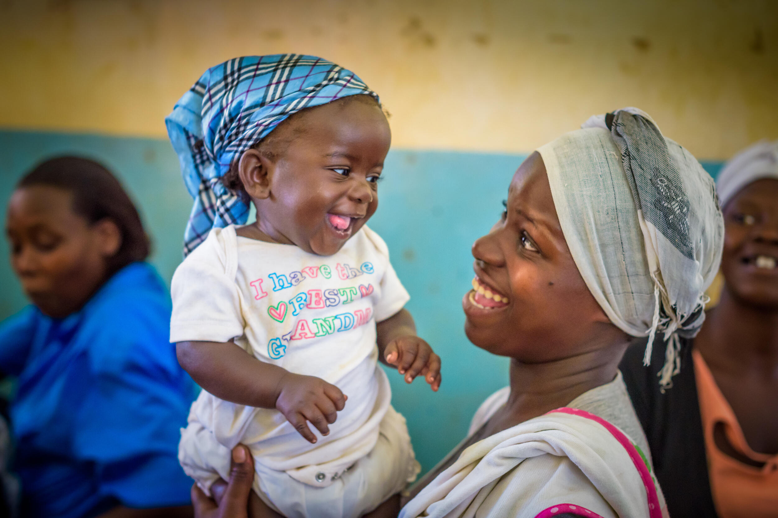 Eine Mutter aus Uganda lächelt ihr Baby an