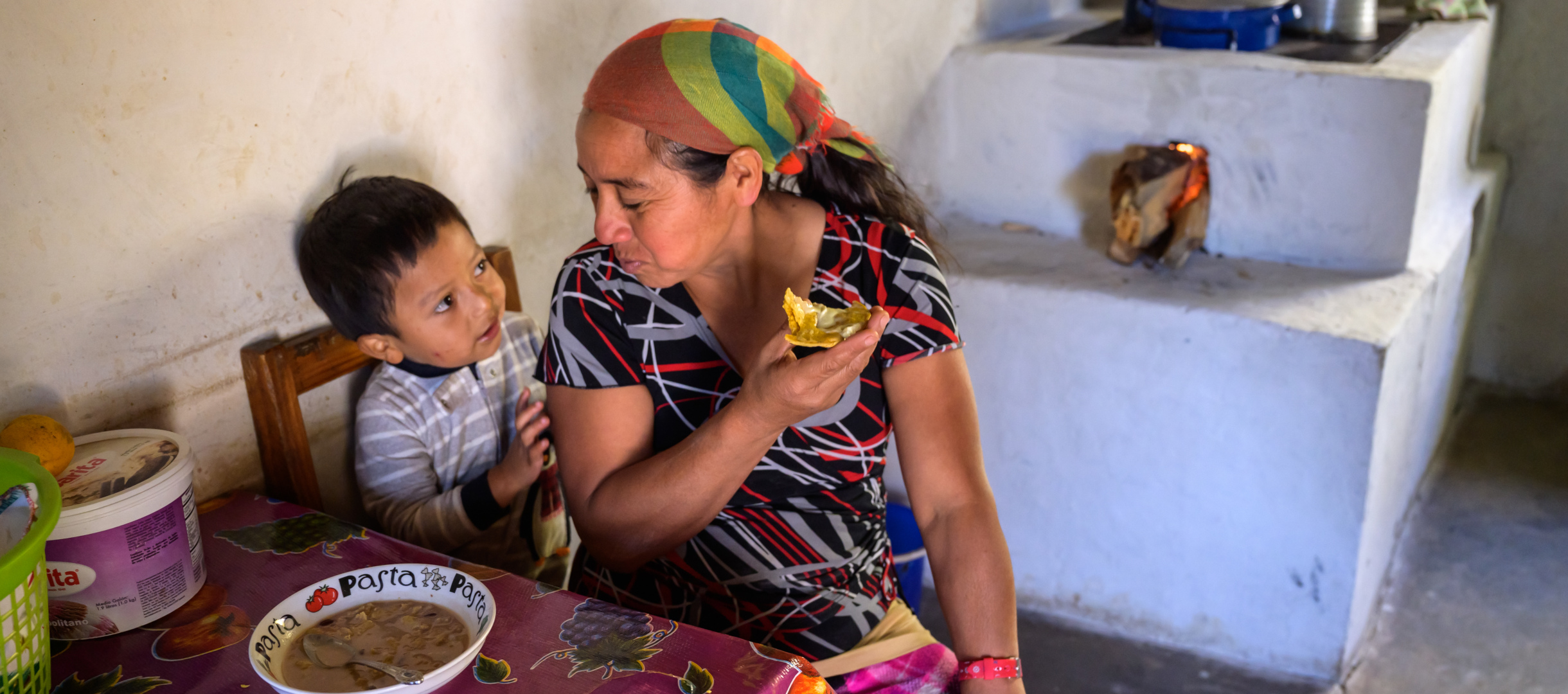 Carmen aus Honduras isst gemeinsam mit ihrem Enkel. 
