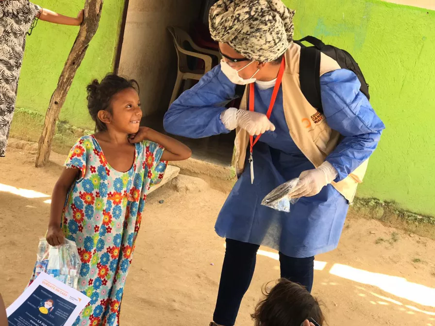 Ein Mädchen erhält aufmunternde Zuwendung und Informationen zur Prävention von  COVID-19