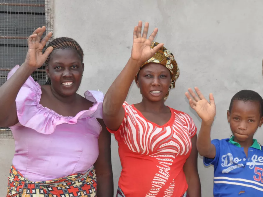 Winkende Menschen am Straßenrand