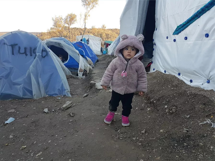 Ein kleines Mädchen steht im Zeltlager auf Moria.