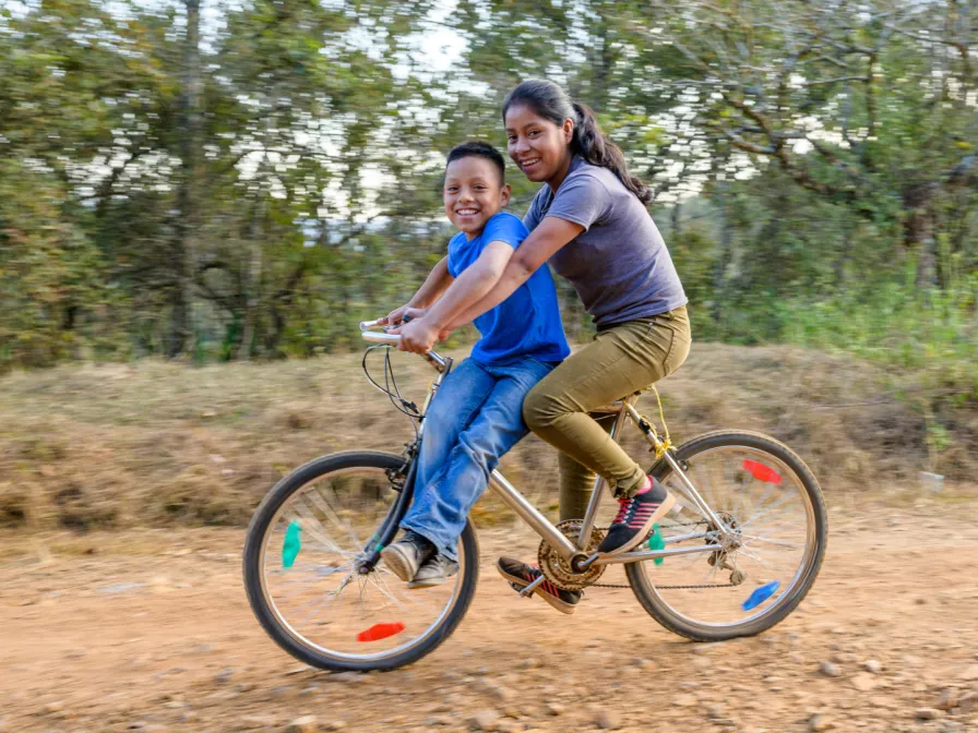 Mädchen und Junge auf einem Fahrrad in Honduras