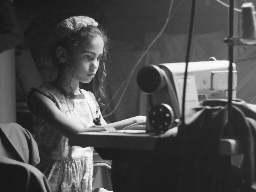 Als KINDHEITSRETTER Kindern in Not helfen: Mädchen sitzt an einer Nähmaschine