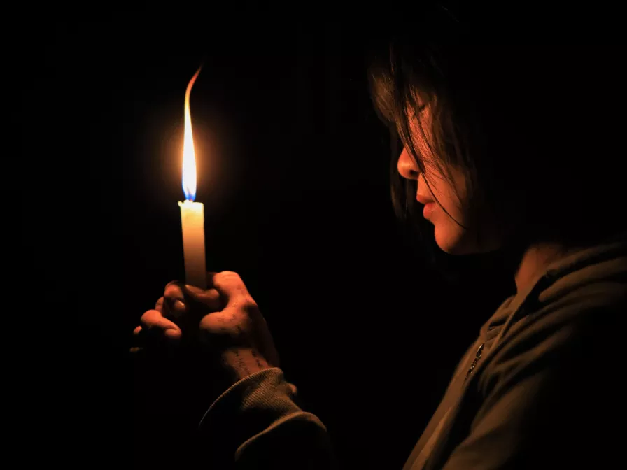 Symbolbild: Ein Mädchen aus Myanmar schaut auf eine brennende Kerze
