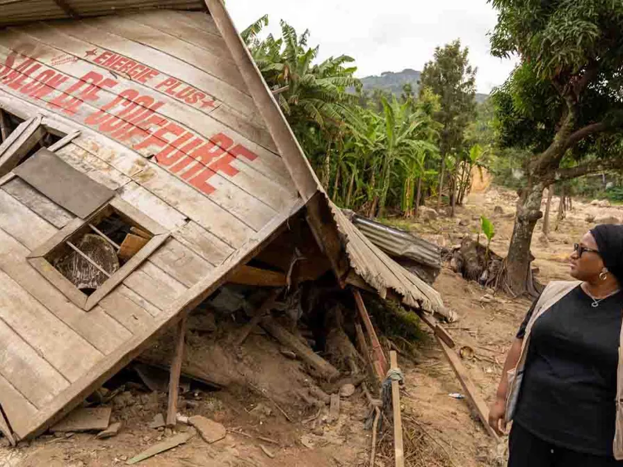 Frau vor einem von Flut zerstörten Friseursalon in Kongo