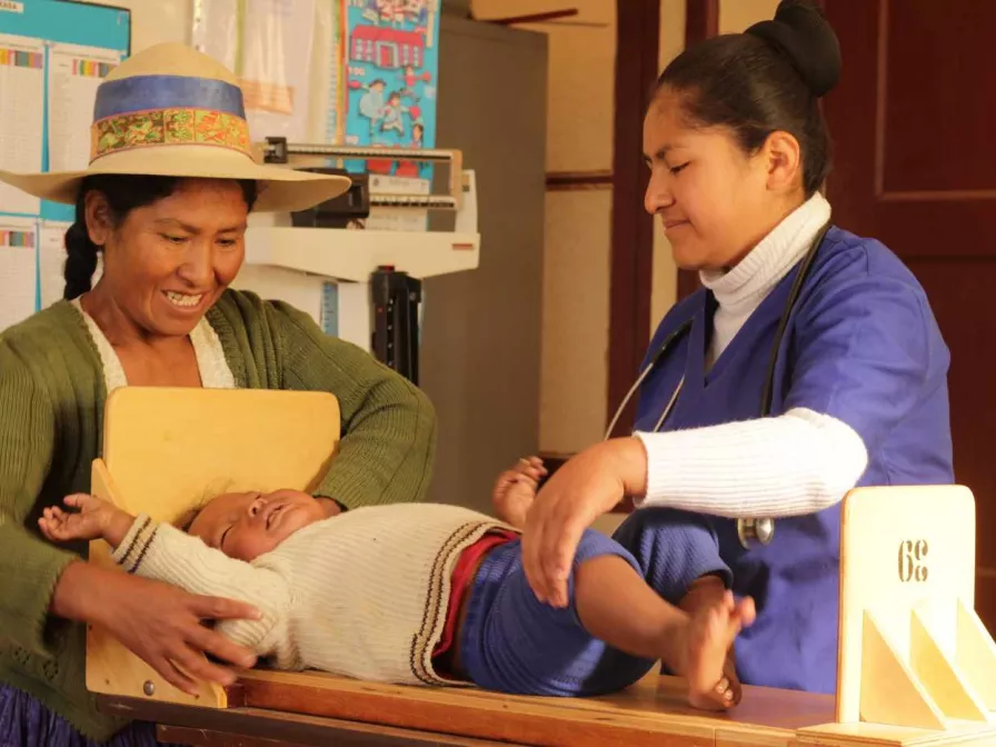 Mutter mit Baby bei einer medizinischen Untersuchung in Bolivien