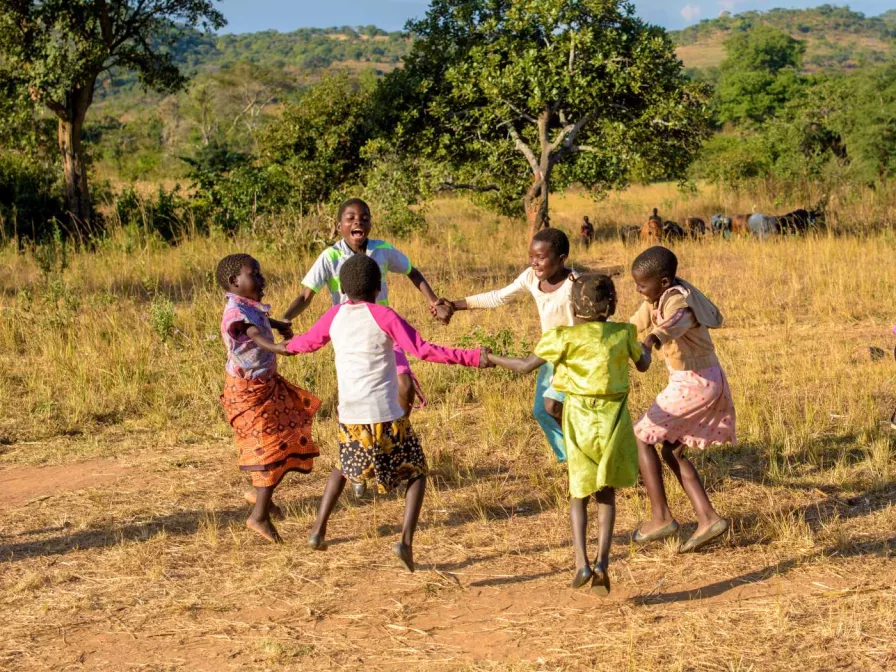 Glückliche Kinder die im Kreis tanzen 