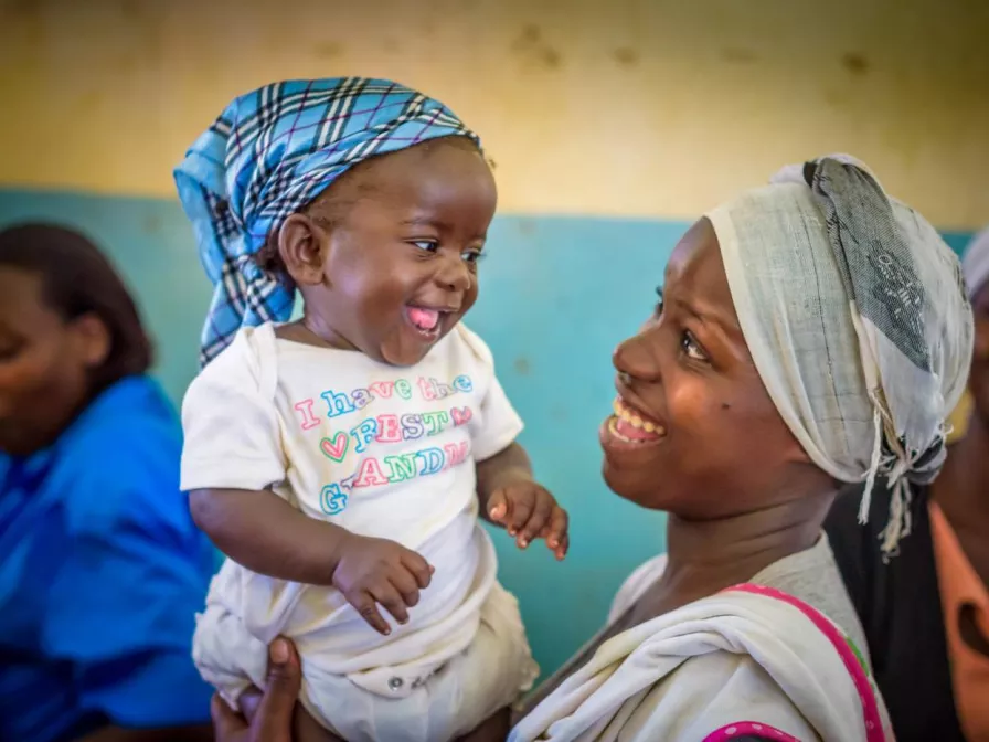 Mutter hält ihr Kind hoch und lacht