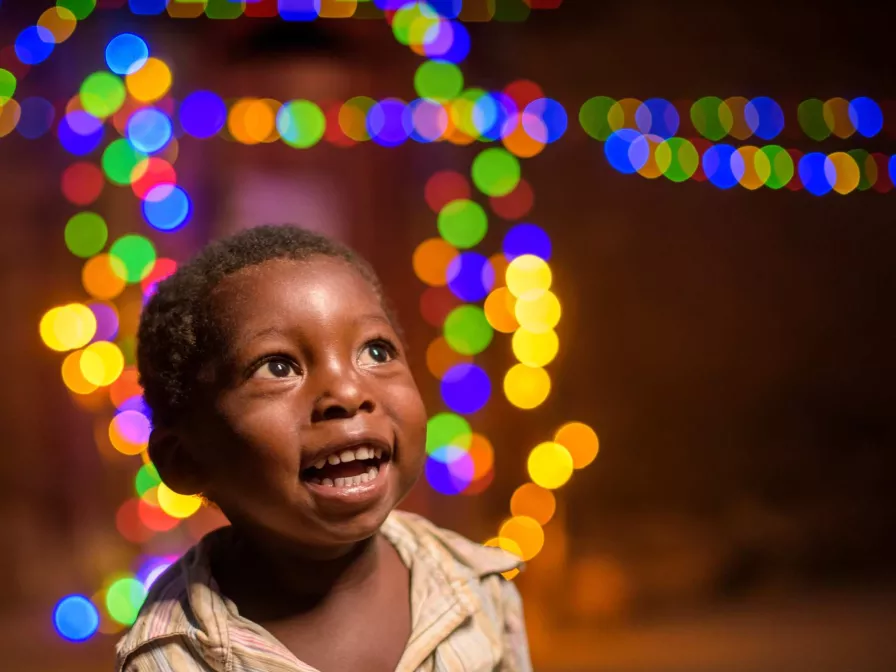 Ein Kind aus Sambia freut sich über ein Weihnachtsgeschenk von seinem Paten.