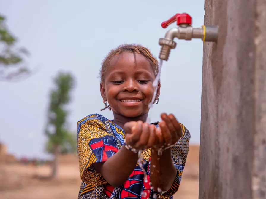 Kind mit einem Wasserhahn