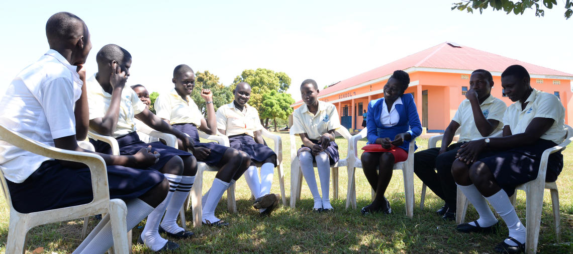 Lehrerin Elizabeth aus Uganda im Kreis mit ihren Schülerinnen und Schülern 