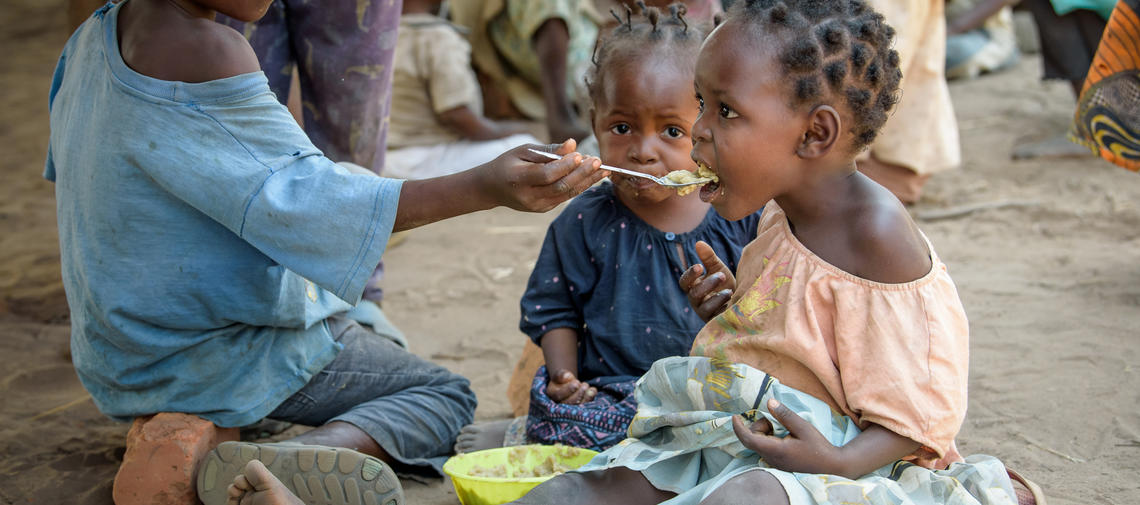 Ein Junge aus der DR Kongo füttert seine Schwester