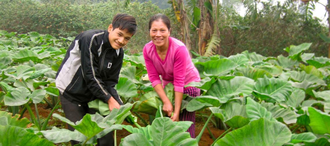 Eine Mutter pflegt gemeinsam mit ihrem Sohn ihren Garten
