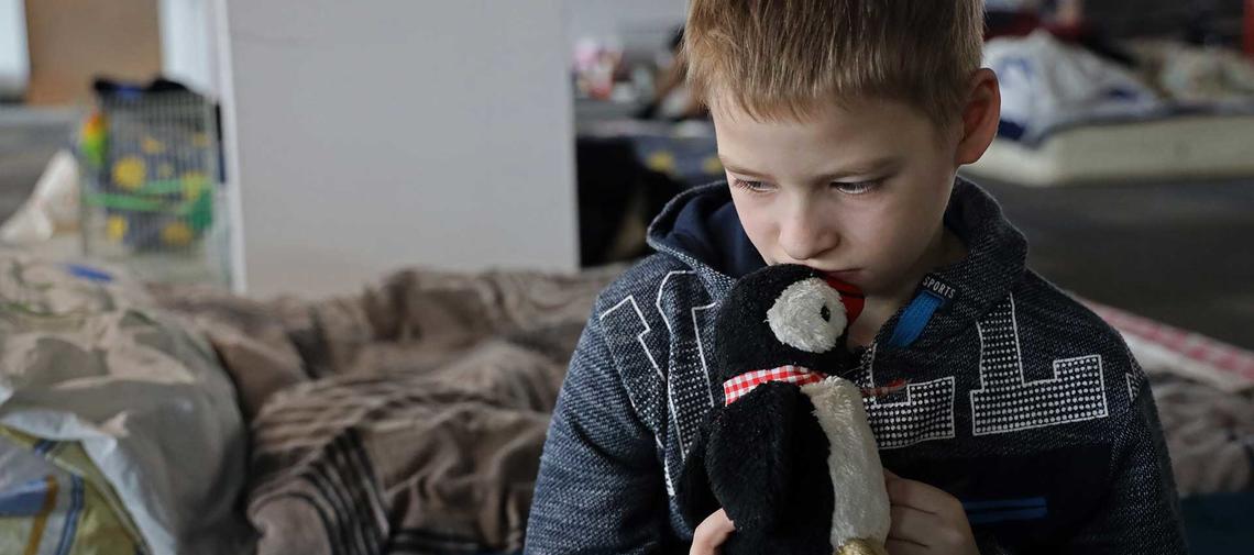 aus der Ukraine geflohener Junge mit seinem Kuscheltier
