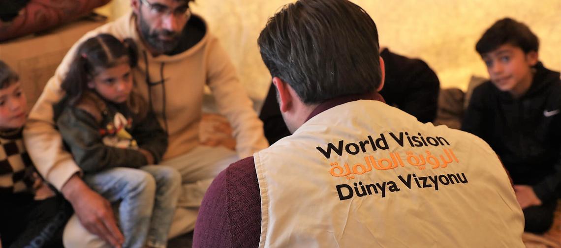 World Vision-Mitarbeiter in Syrien spricht mit einer vom Erdbeben betroffenen Familie