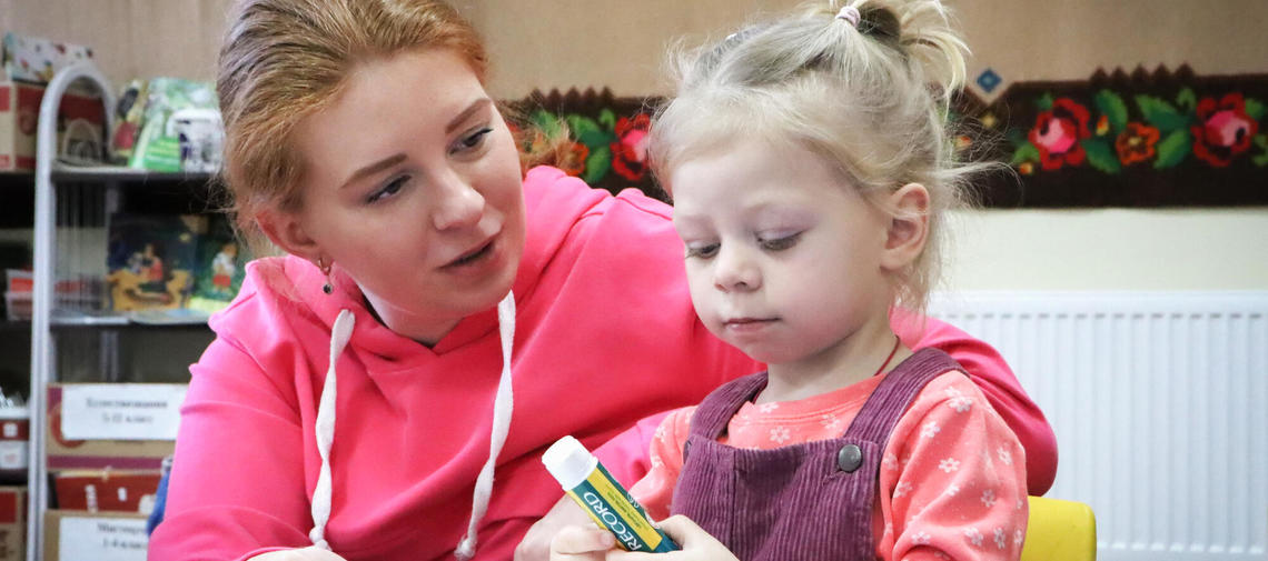 Kataryna aus der Ukraine hilft ihrer kleinen Tochter beim Basteln.