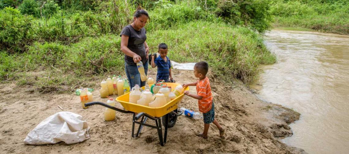 Mutter mit Kindern an einem Fluss in Honduras