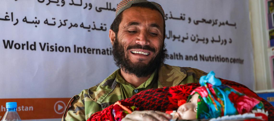 Ein afghanischer Vater zeigt stolz sein Baby bei einer Gesundheitsberatung von World Vision