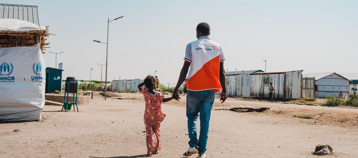 World Vision-Helfer mit geflüchtetem Kind aus Sudan