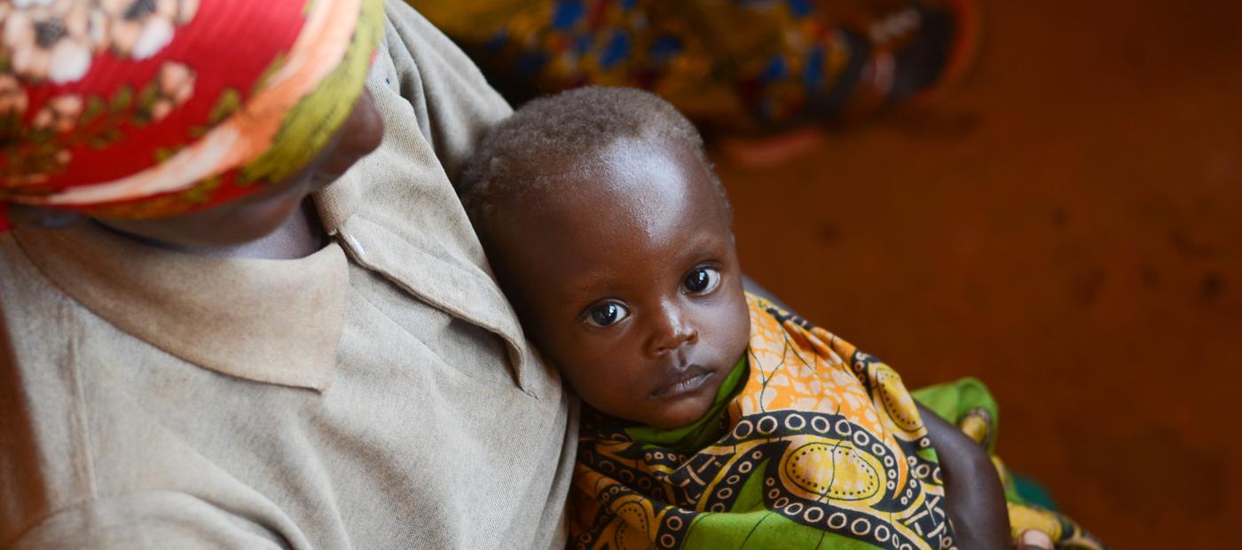 Mädchen auf dem Schoß seiner Mutter in Burundi