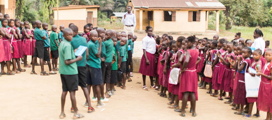 Schulkinder stellen sich vor ihrer Schule in Sierra Leone auf.