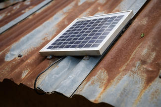 Ein Solarpanel auf dem Dach sammelt Strom für die Lampen im Haus in Kogel'o / Kenia.