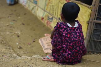Allein sitzendes Mädchen im Flüchtlingslager in Bangladesch