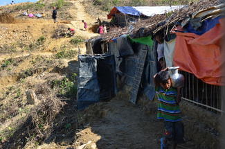 Ein Junge holt Wasser auf engen Wegen im Flüchtlingslager in Bangladesch