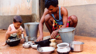 Gleichberechtigung: Ein indischer Vater hilft seinem Kind beim Geschirrspülen