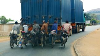 Radfahrer lassen sich von einem Lastwagen ziehen.