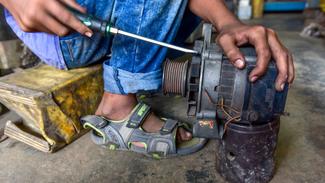 Junge, der in einer Werkstatt arbeitet