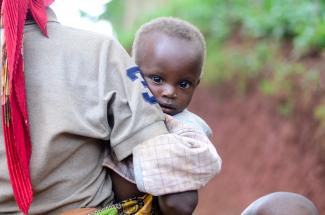 Mädchen auf dem Arm seiner Mutter in Burundi