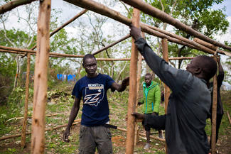 Neu angekommene Flüchtlinge aus Südsudan bauen sich ein Haus in Nordwest-Uganda