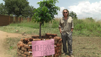 Wolfgang Niedecken pflanzt 2009 zur Eröffnung der Schule in Gulu einen Baum