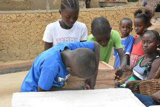 Die Kinder der Spargruppe Destiny sichern ihre Einlagen in einer massiven Holzkiste