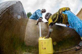 Patenkind Isabelle aus Ruanda und ihr kleiner Bruder holen Wasser aus dem neuen Wasserhahn.