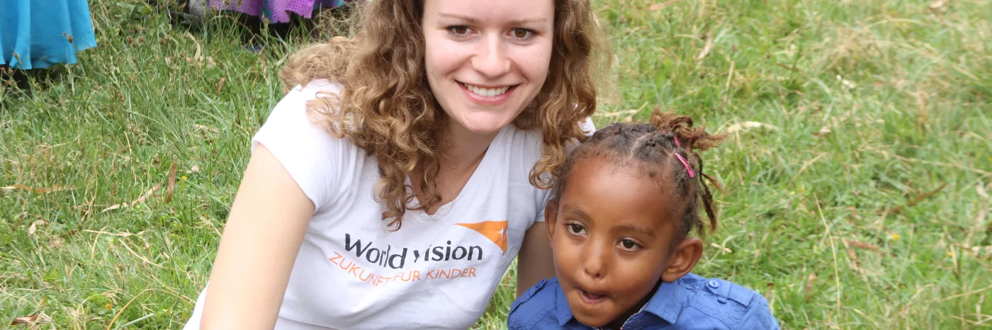 Mitarbeiterin Tatjana mit einem Patenkind bei einem Projektbesuch in Ghana