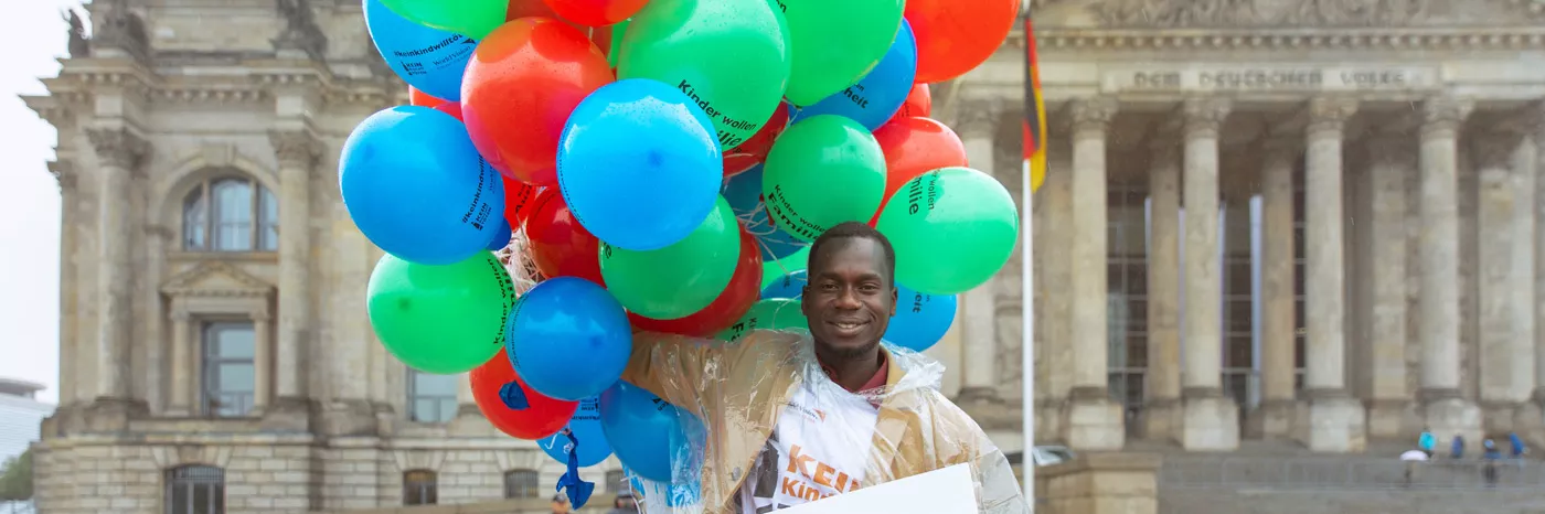 Innocent Owonya spricht bei der World Vision-Aktion am Bundestag im Namen vieler ehemaliger Kindersoldaten die auf eine Chance zu einem Leben ohne Gewalt hoffen.