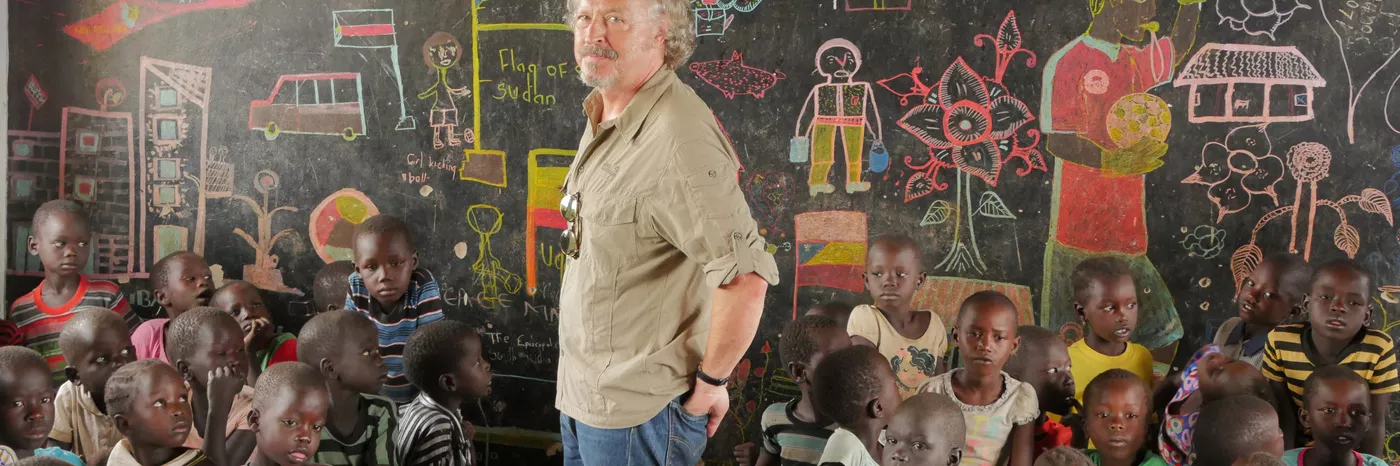 Musiker Wolfgang Niedecken schaut sich Zeichnungen geflüchteter Kinder in Bidi Bidi - Uganda an. 