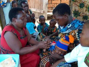 Frau misst Armumfang eines Kindes