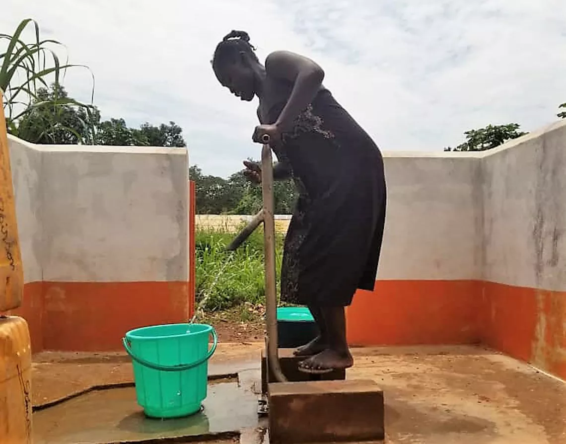 Ein Frau in der zentralafrikanischen Republik pumpt Wasser aus einem neuen Brunnen.