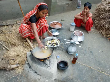 Patenkind Munnis und ihre Mutter bereiten zusammen das Fischcurry zu.
