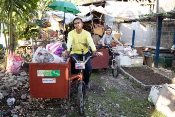 Recycling-Mitarbeiter sammeln u.a. Plastikmüll per Fahrrad in Cotabato City